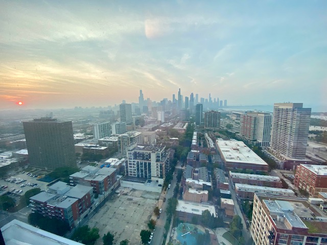 Chicago skyline reflected on Lake Michigan as the sun sets over downtown Chicago.