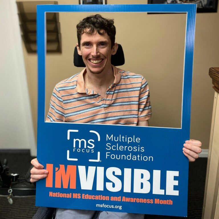 Sean Giblin smiling through a blue MS Focus “I’M VISIBLE” frame.